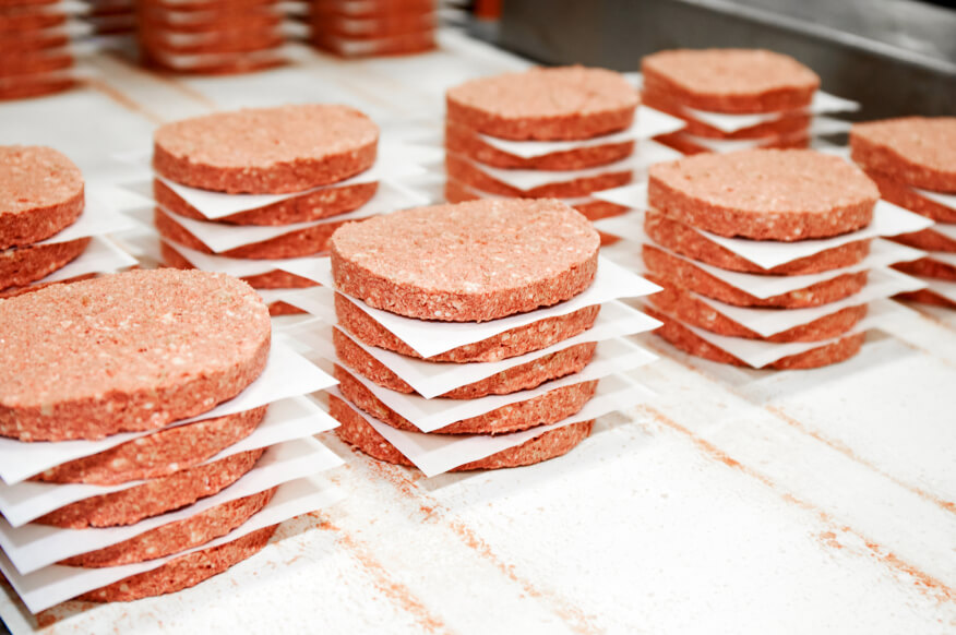 Picture of burger patties stacked up ready to cook